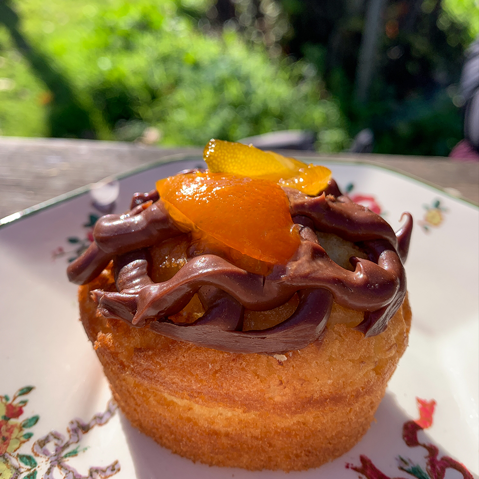 עוגת לימון עם קרמו שוקולד וריבת קומקוואט על צלחת פרחונית בגן היפה של אלורו בית ילין