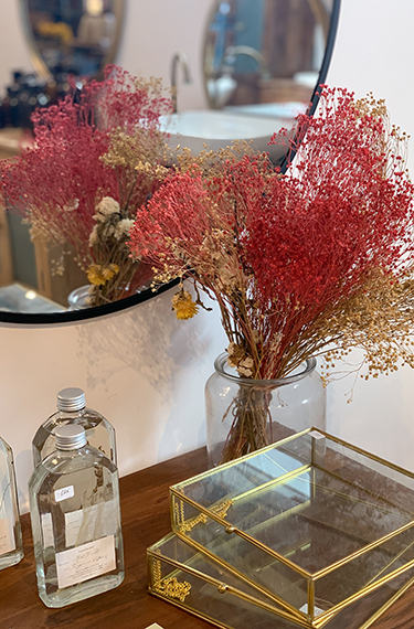 אגרטל עם פרחים יבשים על מדף ולידם מראה בחנות הרהיטים המהממת תומיק באבן יהודה