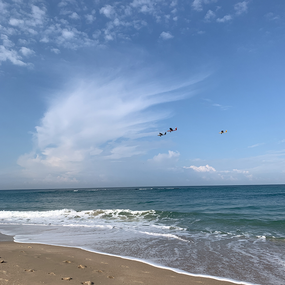 חוף פמלחים היפה עם ענן לבן ברקע וכלי טיס מעליו